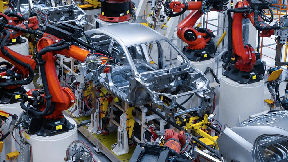 Robot industriali e scocche di automobili su una linea di produzione automotive